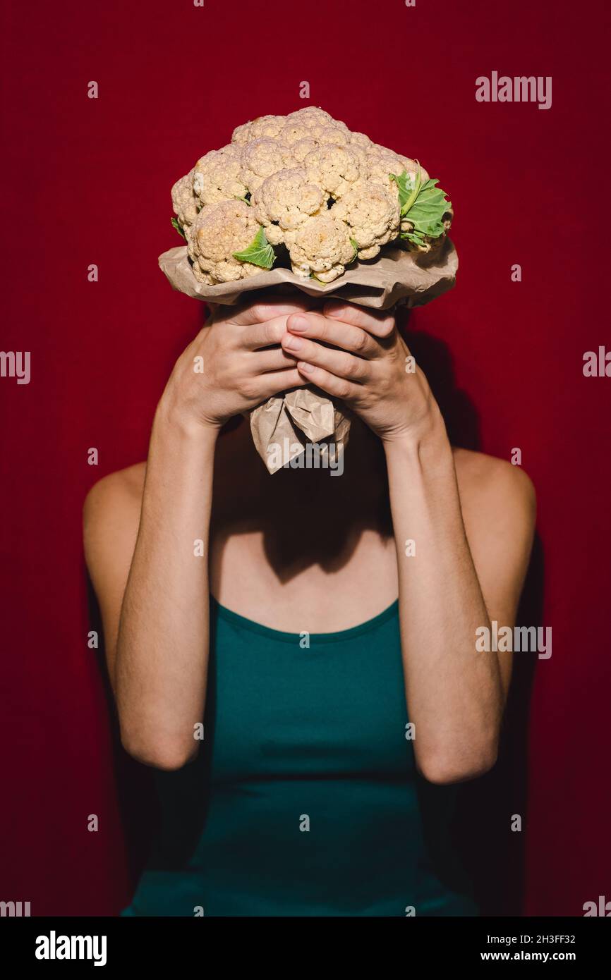 Modèle triché posant avec le chou-fleur. Banque D'Images