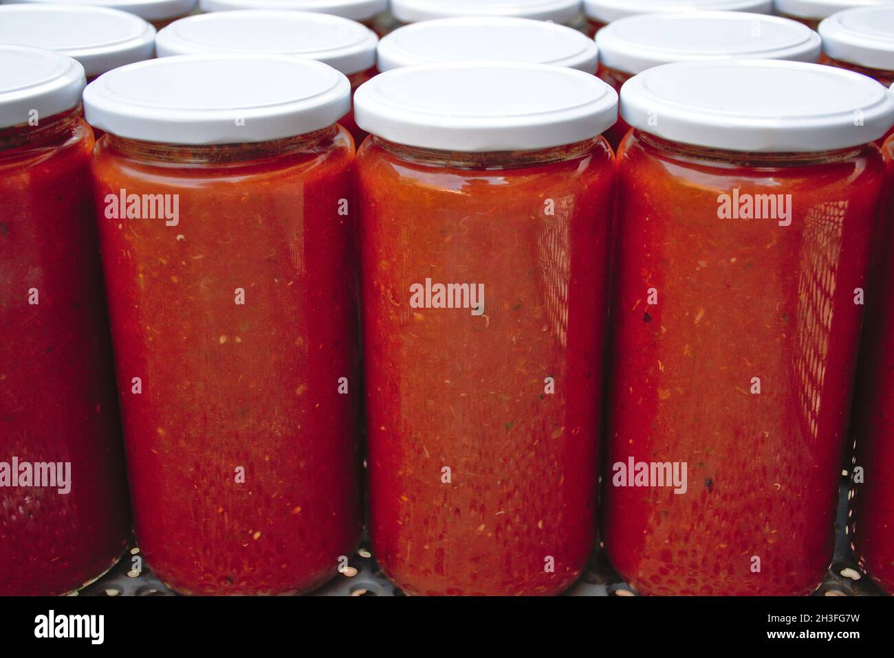 Pots de tomates faits maison.Pots en verre avec couvercle blanc.Faites frire les tomates à l'intérieur avec de la ratatouille végétale. Banque D'Images