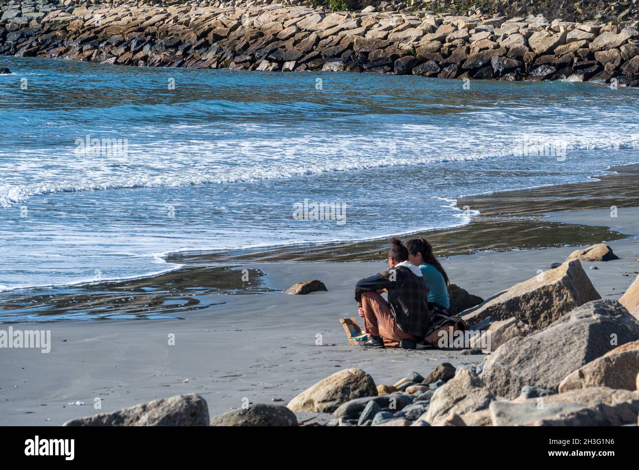 Newport, Rhode Island, États-Unis -- 21 octobre 2021.Un jeune couple se trouve sur la plage de Newport, Rhode Island, à proximité de la célèbre promenade sur les falaises. Banque D'Images