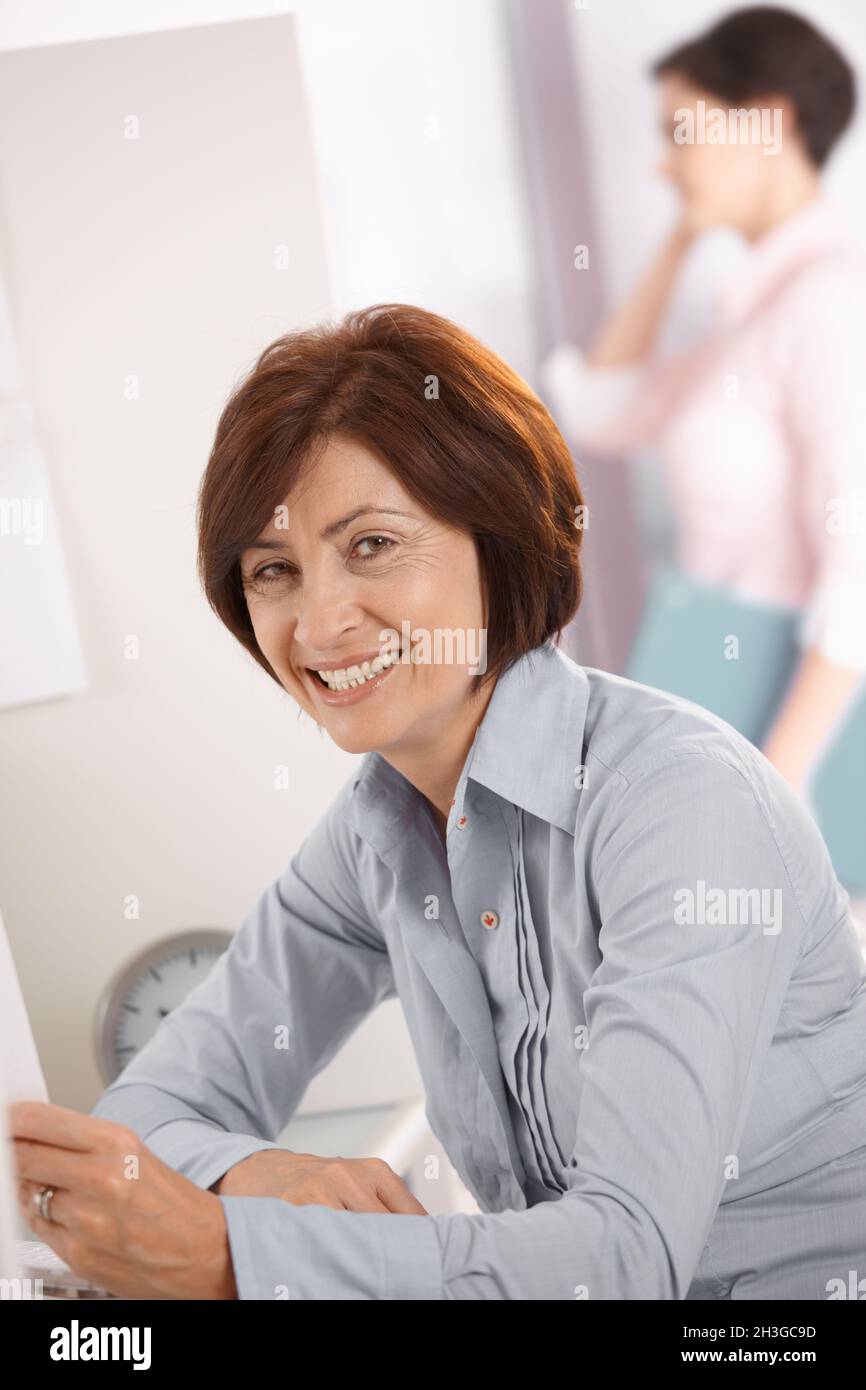 Femme de bureau mûre et souriante Banque D'Images