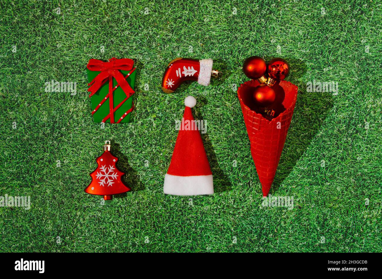 Une infographie ou un motif lumineux fait de décoration de Noël : un arbre de Noël, un cadeau enveloppé, une botte, un chapeau de père Noël et un cône de glace rouge avec rouge Banque D'Images