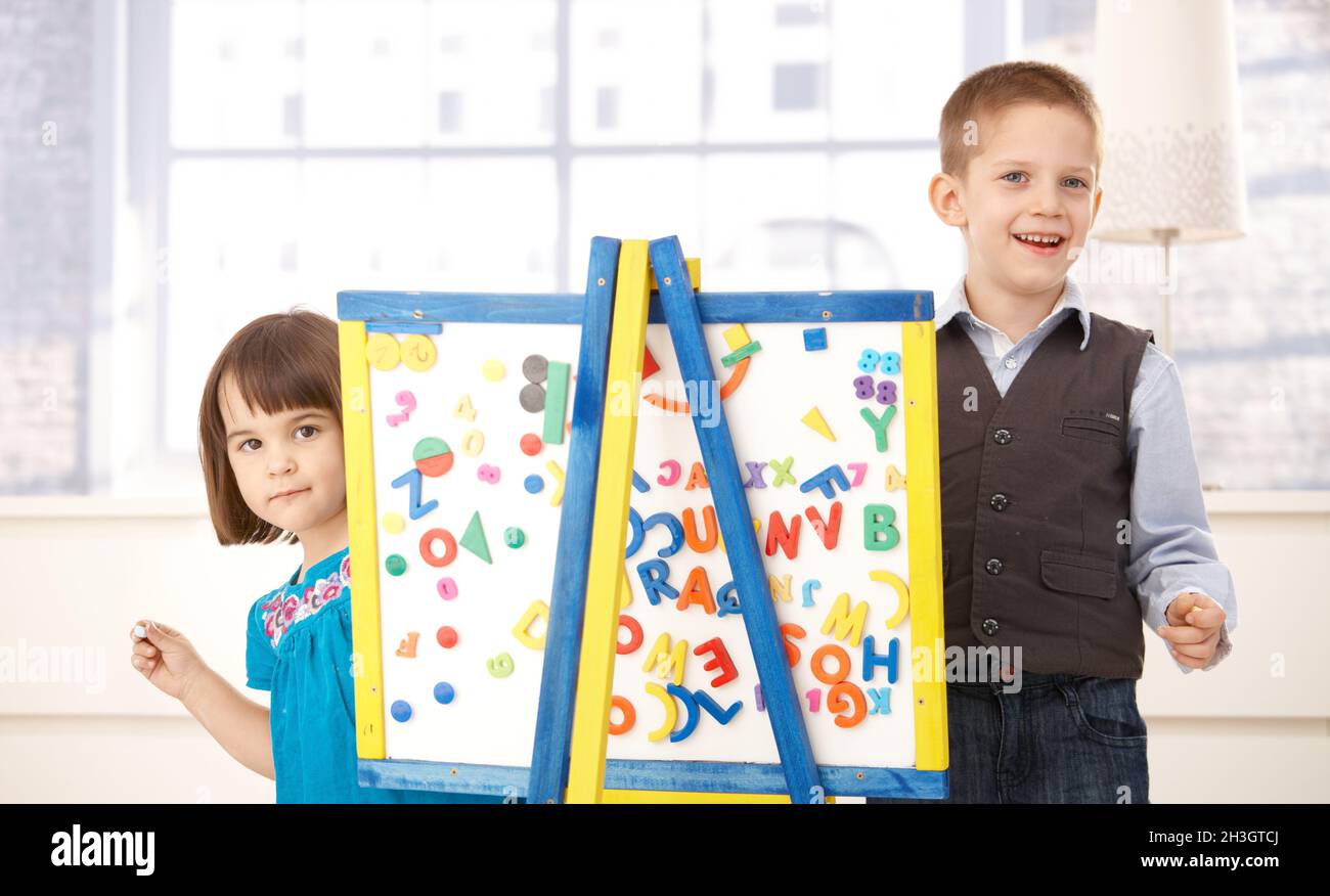 Les enfants sont heureux de jouer avec un tableau à dessin Banque D'Images