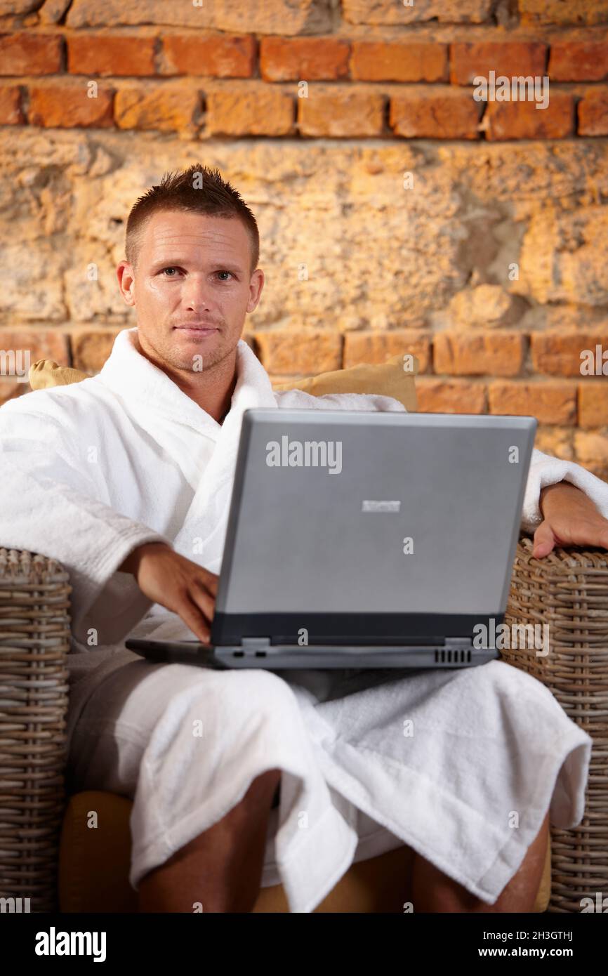 Beau homme en peignoir avec ordinateur Banque D'Images