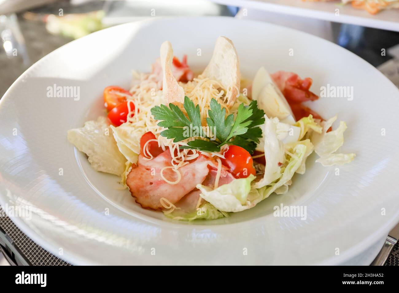 Œufs, croûtons, tomates, salade de jambon dans une assiette blanche sur une table.Photo de haute qualité Banque D'Images