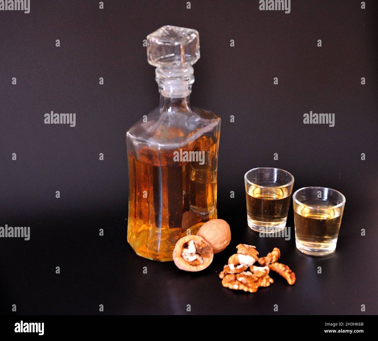 Liqueur maison à base de noix, alcool fort dans les verres et un carafe en  verre sur fond noir.Gros plan Photo Stock - Alamy