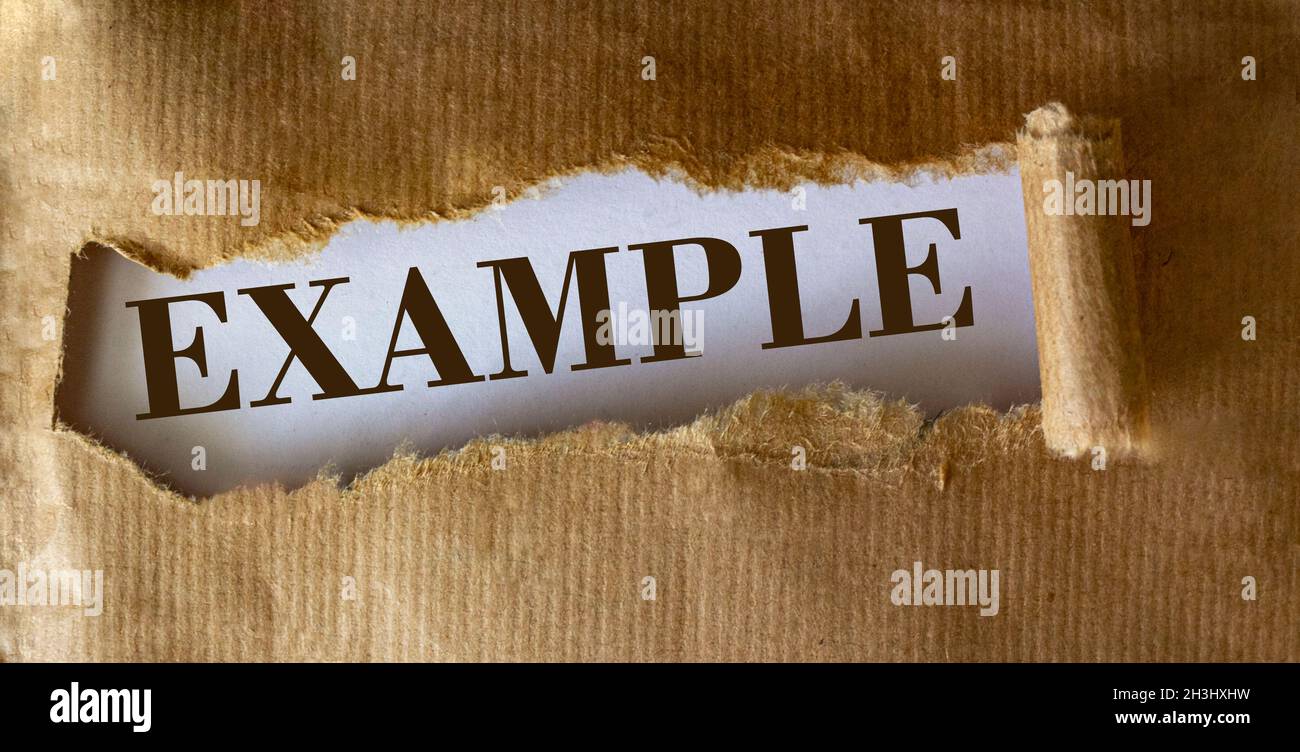Le mot exemple apparaît derrière le papier déchiré. Banque D'Images