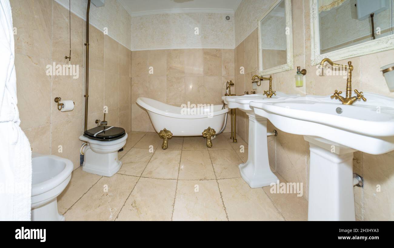 Intérieur moderne de la salle de bains avec toilettes.La salle de douche et les toilettes sont recouvertes de carreaux et d'un lavabo avec miroir au centre. Banque D'Images