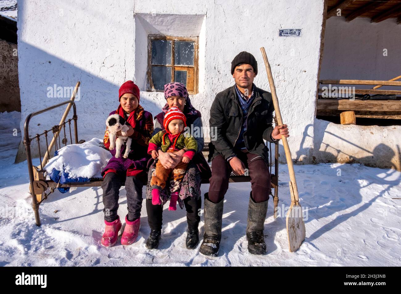 Une famille pose pour une photo devant leur maison à ASRA, Nurata, Ouzbékistan Banque D'Images