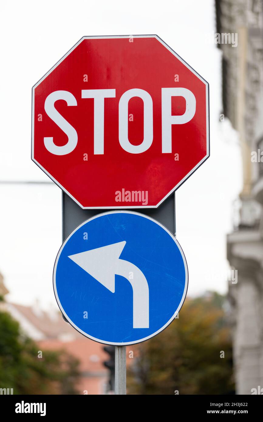 Gros plan sur les panneaux de signalisation dans la ville - arrêt et obligatoire sur la gauche Banque D'Images