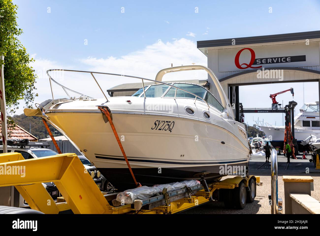 Transport en bateau, Searay cabine de croisière Sundancer sur un long véhicule transporté par la route et livré à la marina à Church point, Sydney, Australie Banque D'Images