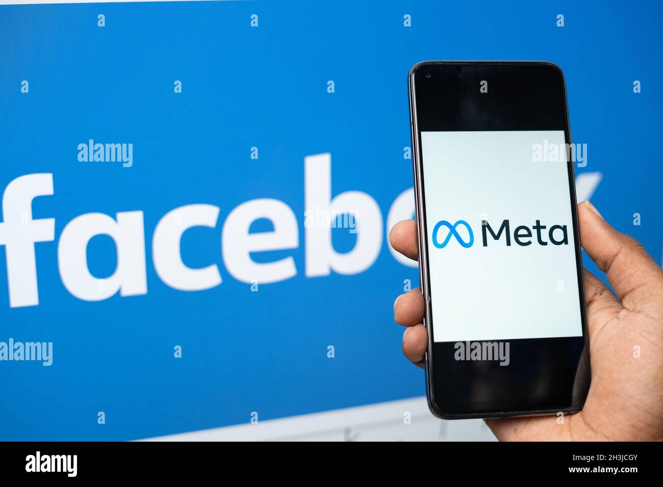 Maski, Inde - 29 octobre 2021 : gros plan des mains tenant le nouveau nom de Meta facebook sur le téléphone mobile avec le nouveau logo facebook en arrière-plan. Banque D'Images