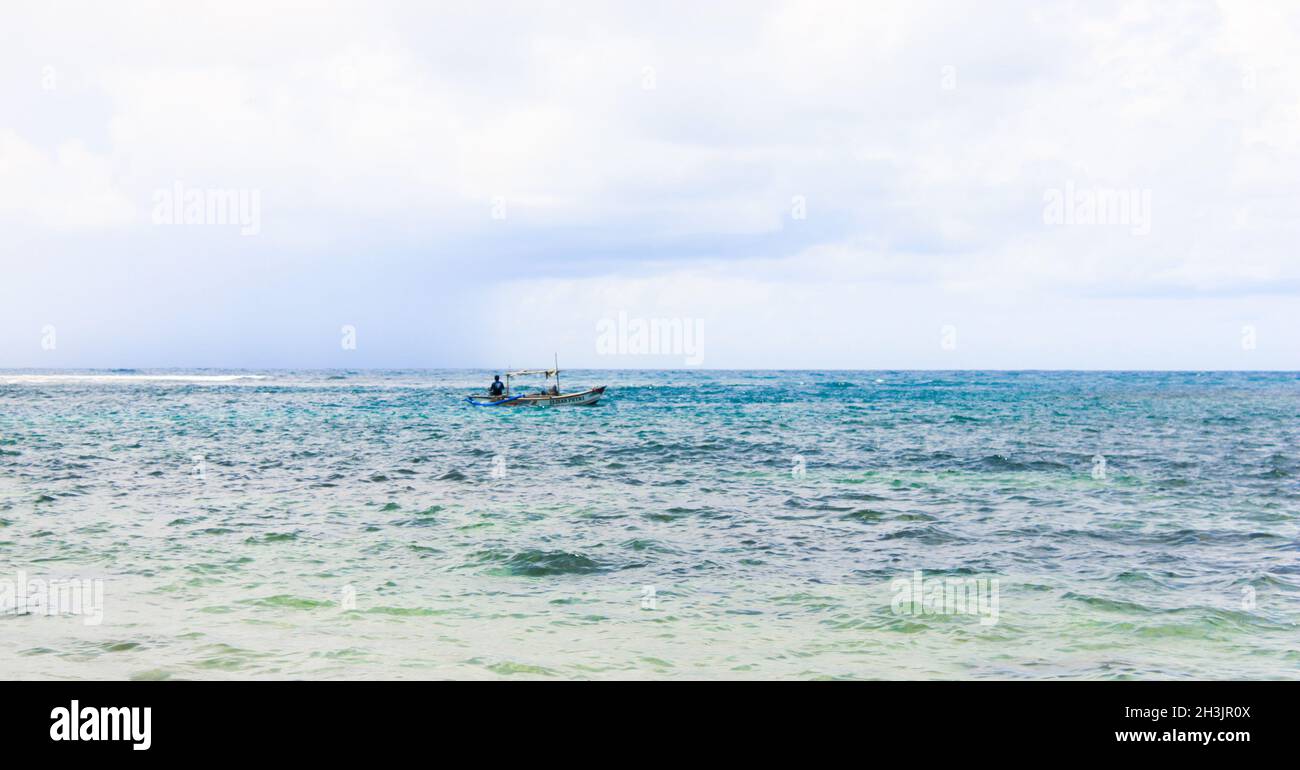 Un bateau passant par l'océan près d'une plage Banque D'Images