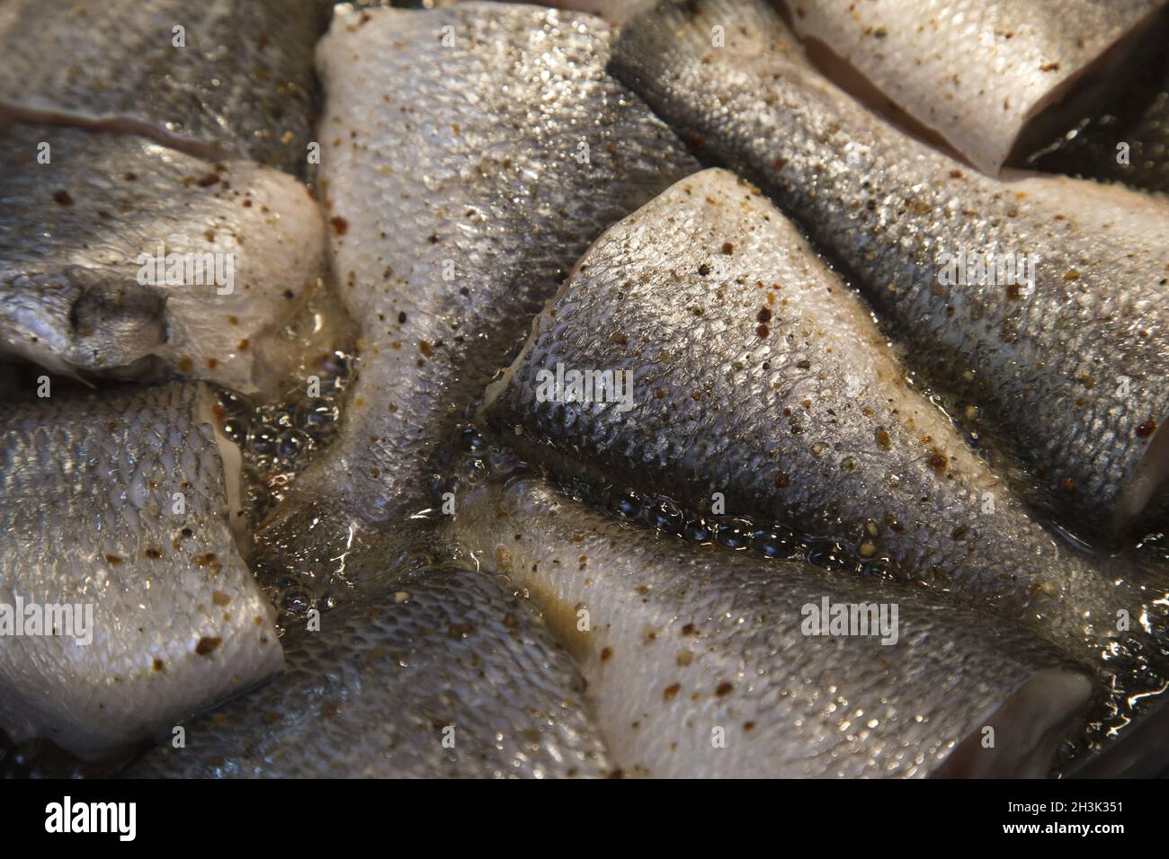 Cuisson du poisson, des poissons frits dans de l'huile chaude dans une poêle Banque D'Images