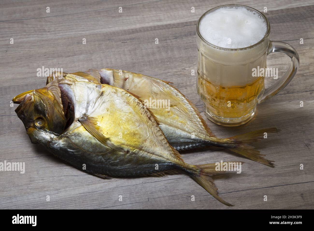 Beer mug et le poisson séché sur la table en bois. Banque D'Images