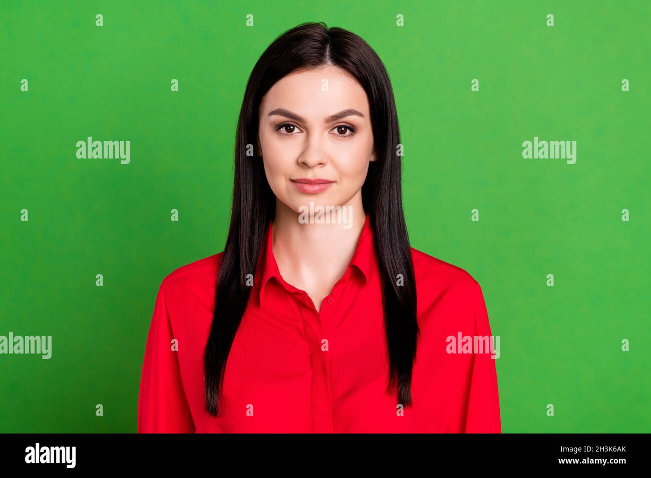 Photo de la belle brunette femme millénaire porter une chemise rouge isolée sur fond vert Banque D'Images