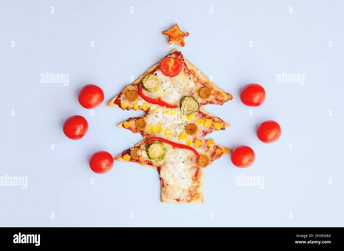 Délicieuse pizza végétarienne aux arbres de Noël avec tomates, légumes et fromage sur fond bleu.Concept alimentaire créatif et amusant pour les enfants.Vue de dessus Banque D'Images