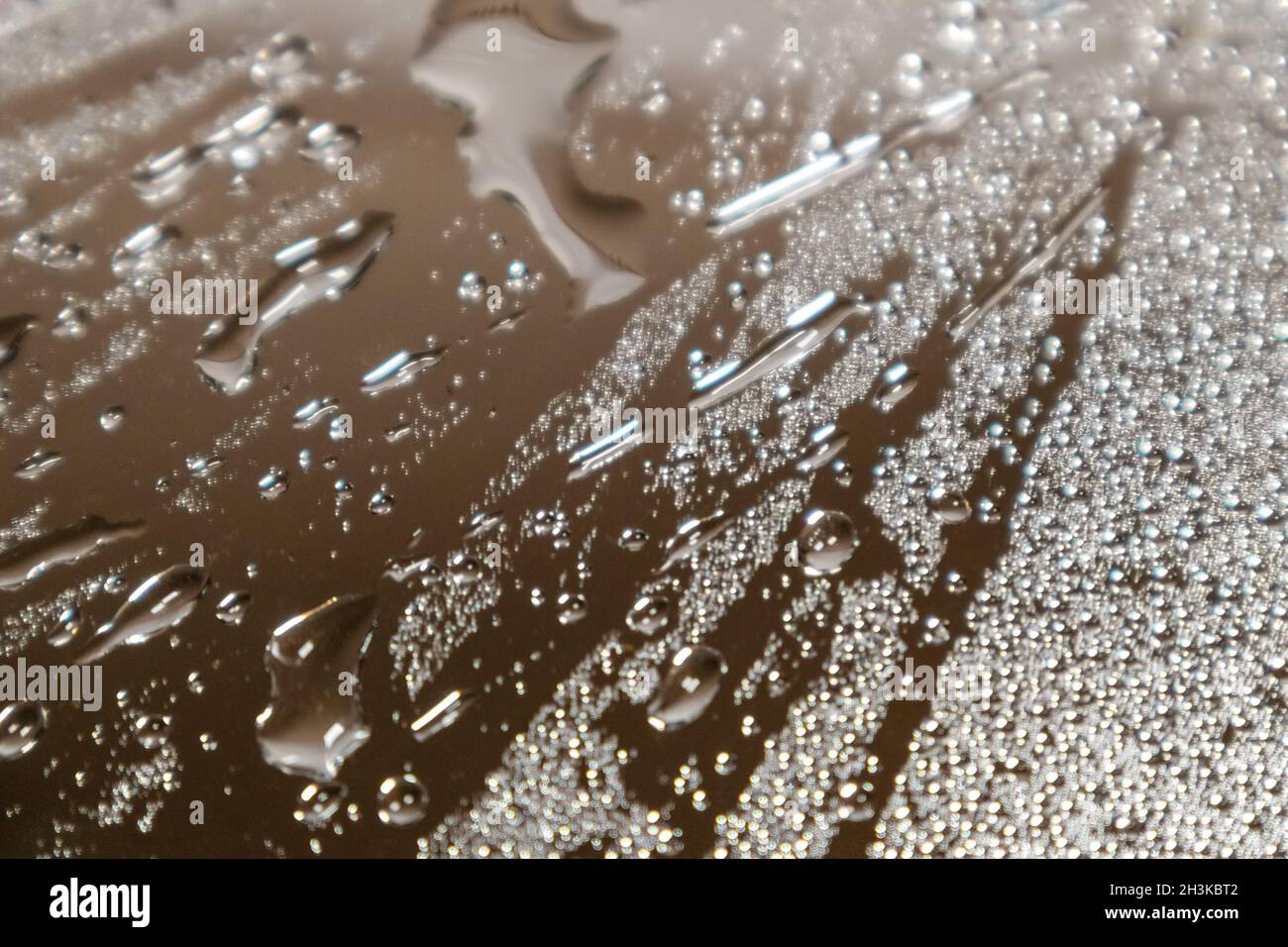 Macro argent de la surface en verre miroir brillant humide avec réflexion et gouttes d'eau.Mise au point sélective et flou Banque D'Images