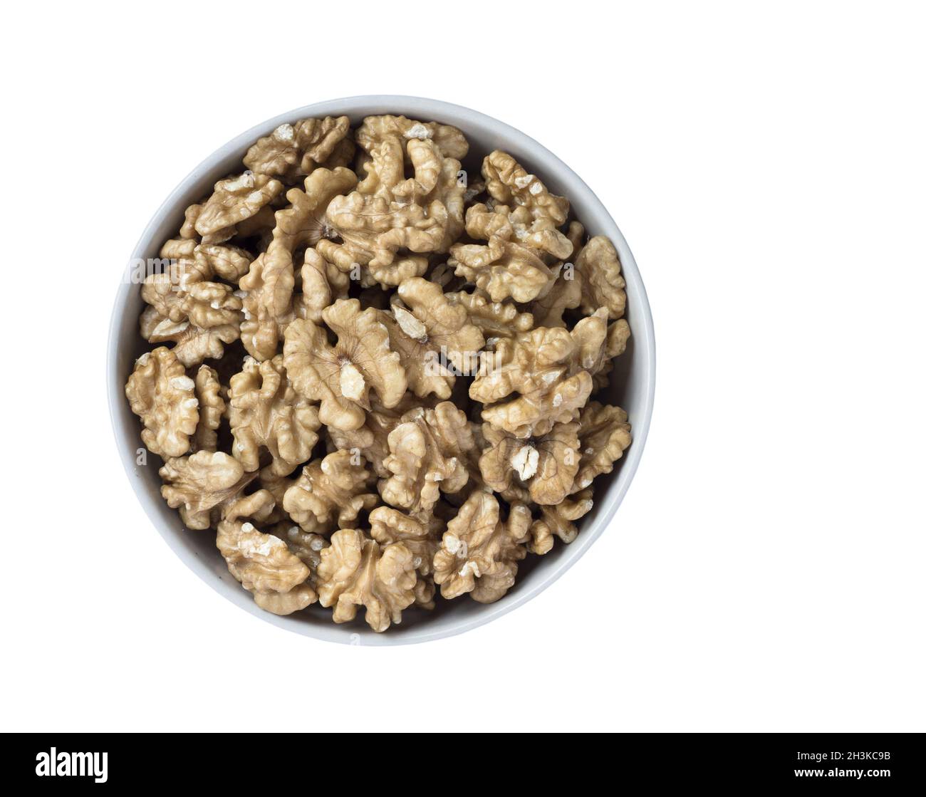 Les cerneaux de noix dans un bol, isolé sur fond blanc, vue du dessus. Banque D'Images