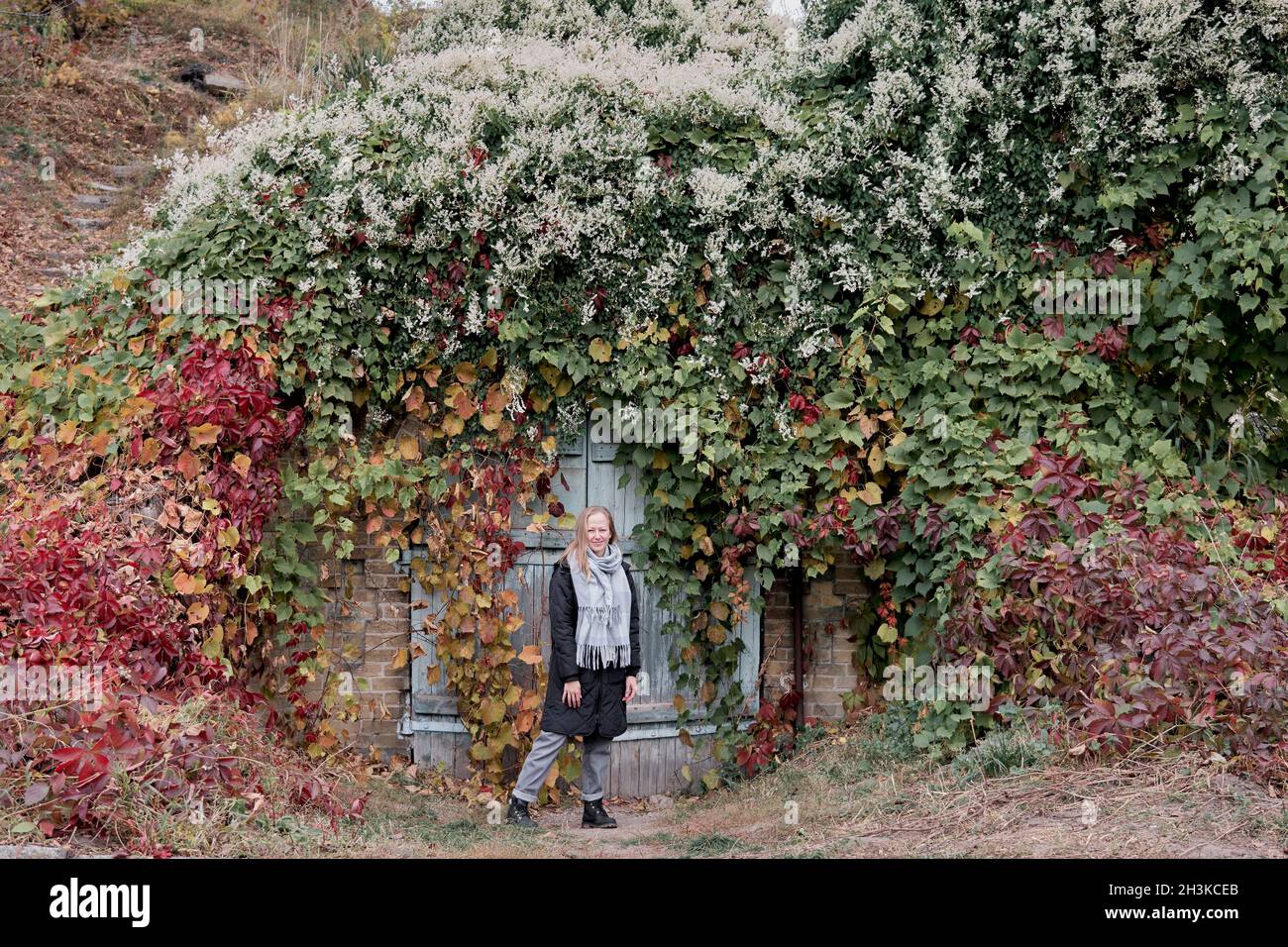Promenade en famille en automne dans la forêt.Magnifique parc avec des feuilles jaunes et rouges sèches.Une mère aimante embrasse sa fille et son fils. Banque D'Images