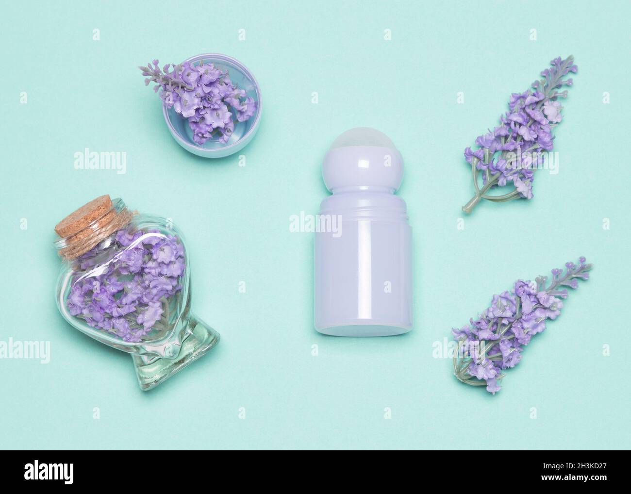 Déodorant antisudorifique pour le corps avec fleurs autour de lui-même et dans sa casquette, vue du dessus.Concept de parfum floral Banque D'Images