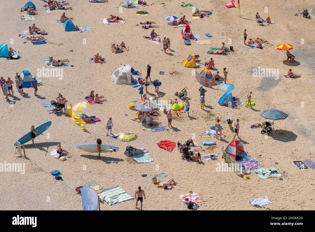 Vacanciers se détendant au soleil sur une plage très fréquentée du Great Western dans la station de vacances de Newquay en Cornouailles. Banque D'Images