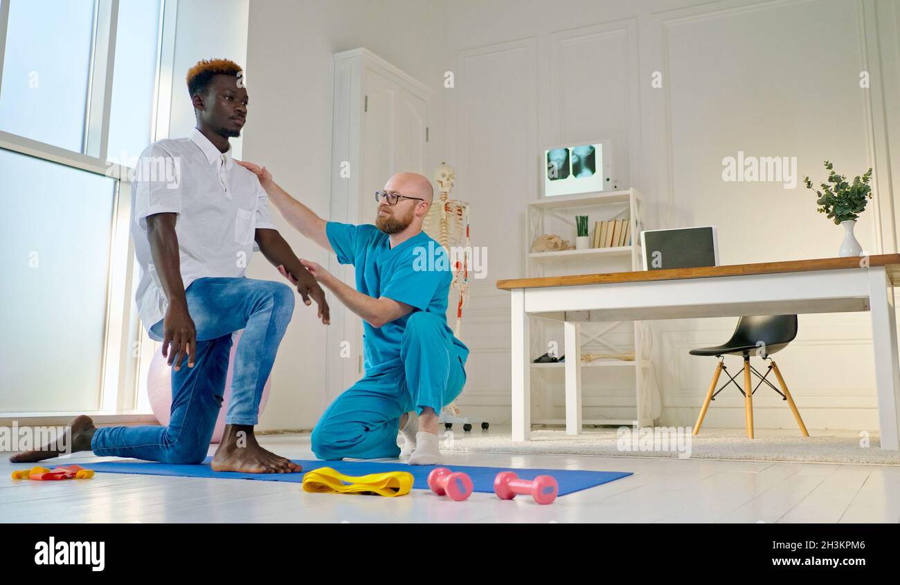 Santé du dos.A Мan effectue des exercices de dos, qui rétablissez les fonctions physiques, dans la clinique de réadaptation moderne.Concept de soins de santé Banque D'Images