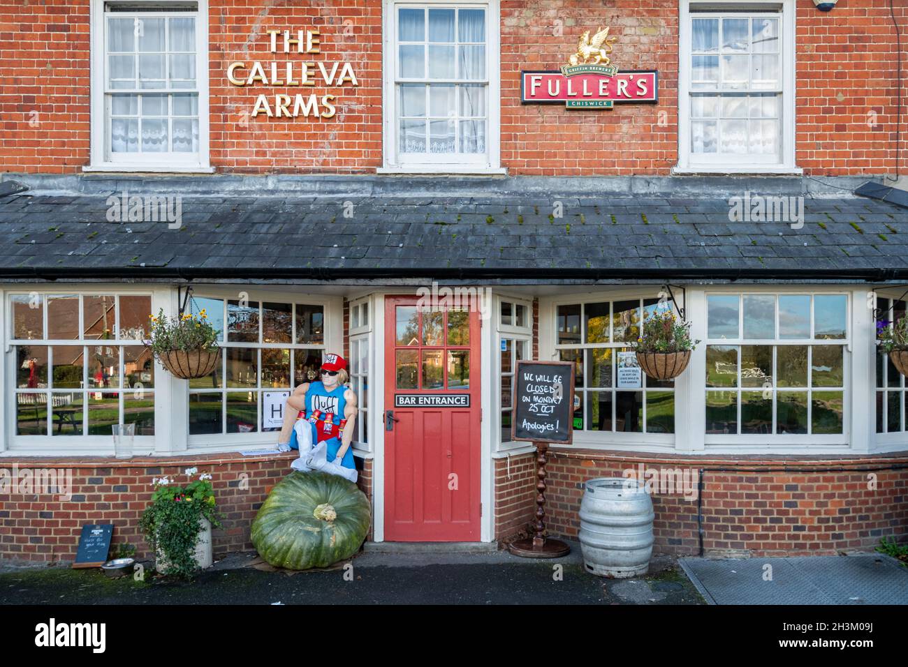 Le pub Calleva Arms à Silchester, un village du Hampshire, en Angleterre, au Royaume-Uni, en octobre avec une arnaque et une grande citrouille à l'extérieur Banque D'Images