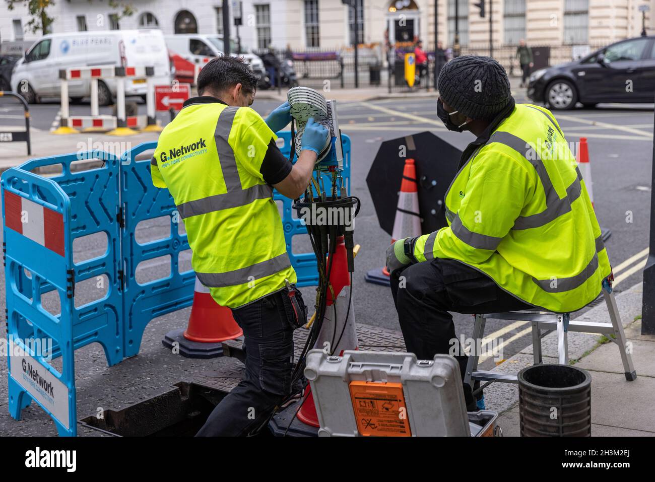« G.Network' ingénieurs connectant des câbles réseau Internet haut débit à fibre optique à l'intérieur d'un boîtier « nœud », dans la région de Fitzrovia, Londres, Angleterre, Royaume-Uni Banque D'Images