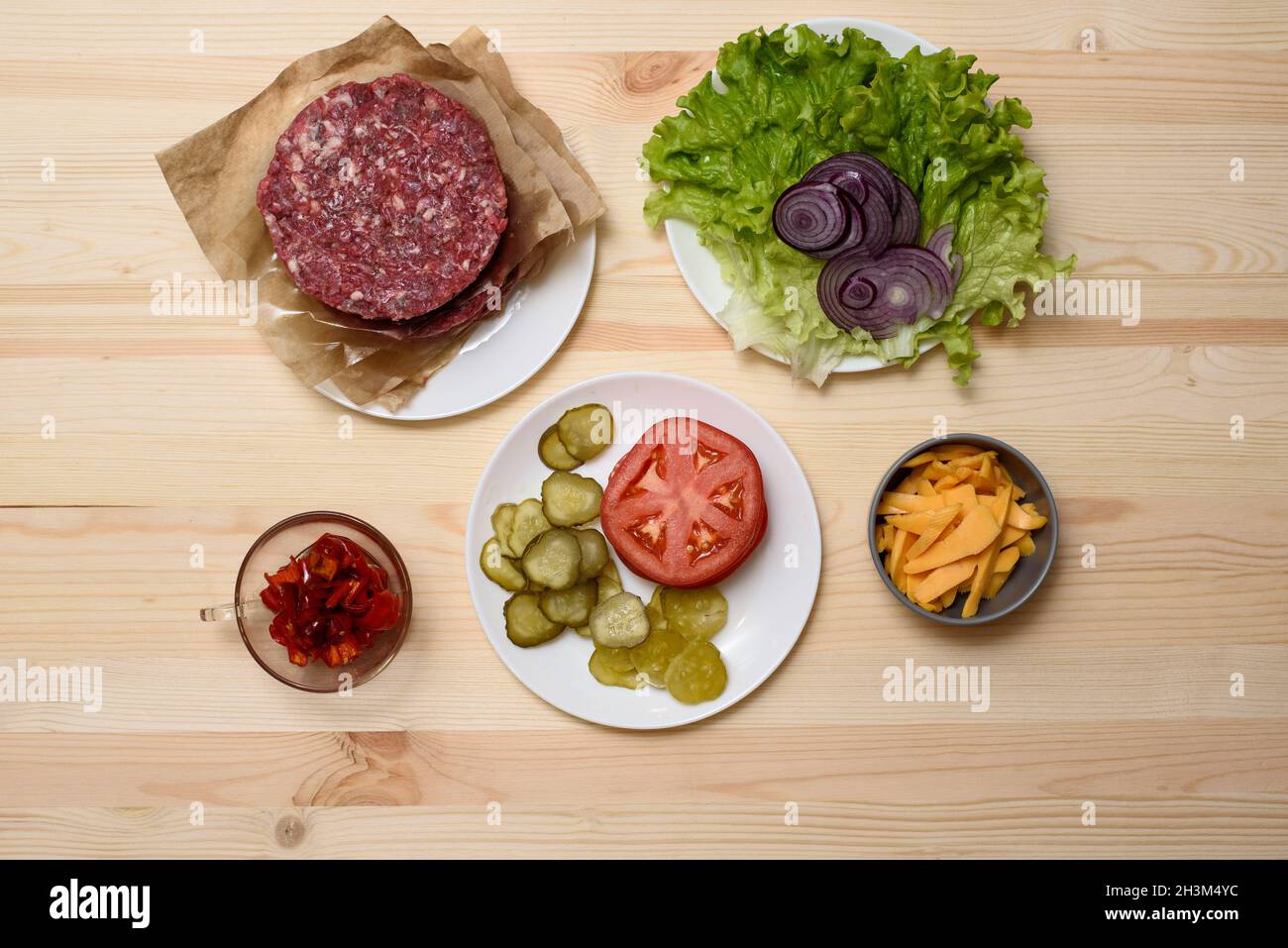 ingrédients pour un hamburger. bœuf, laitue, oignon, fromage, tomate,concombre, poivre Banque D'Images