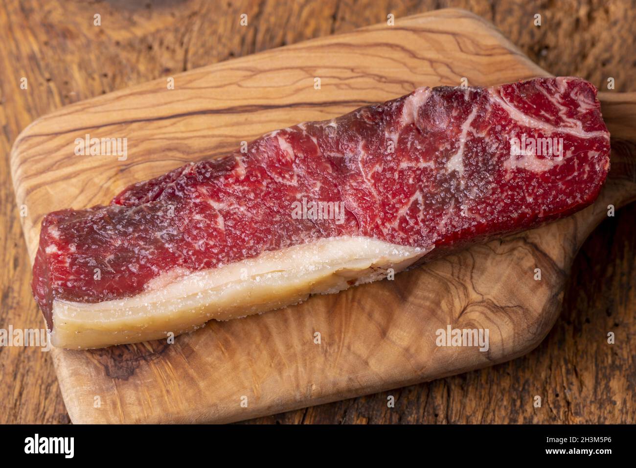 Steak cru sur le bois d'olive Banque D'Images