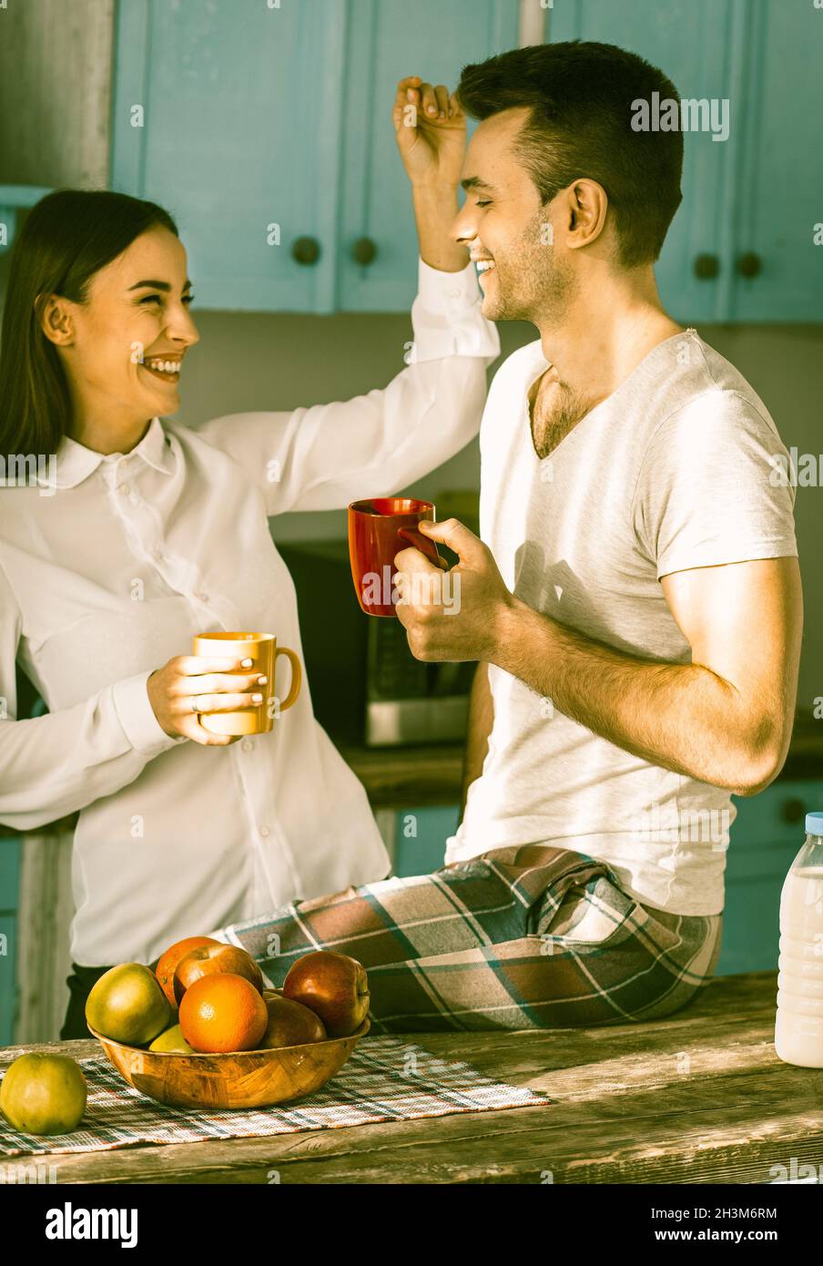 Couple hétérosexuel souriant dans la cuisine intérieure Banque D'Images