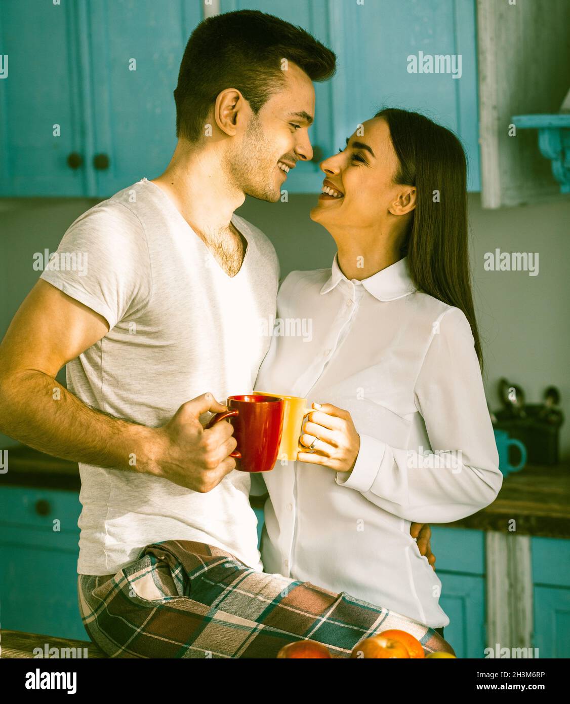 Homme et femme Smiles regardant face à face à la cuisine Banque D'Images