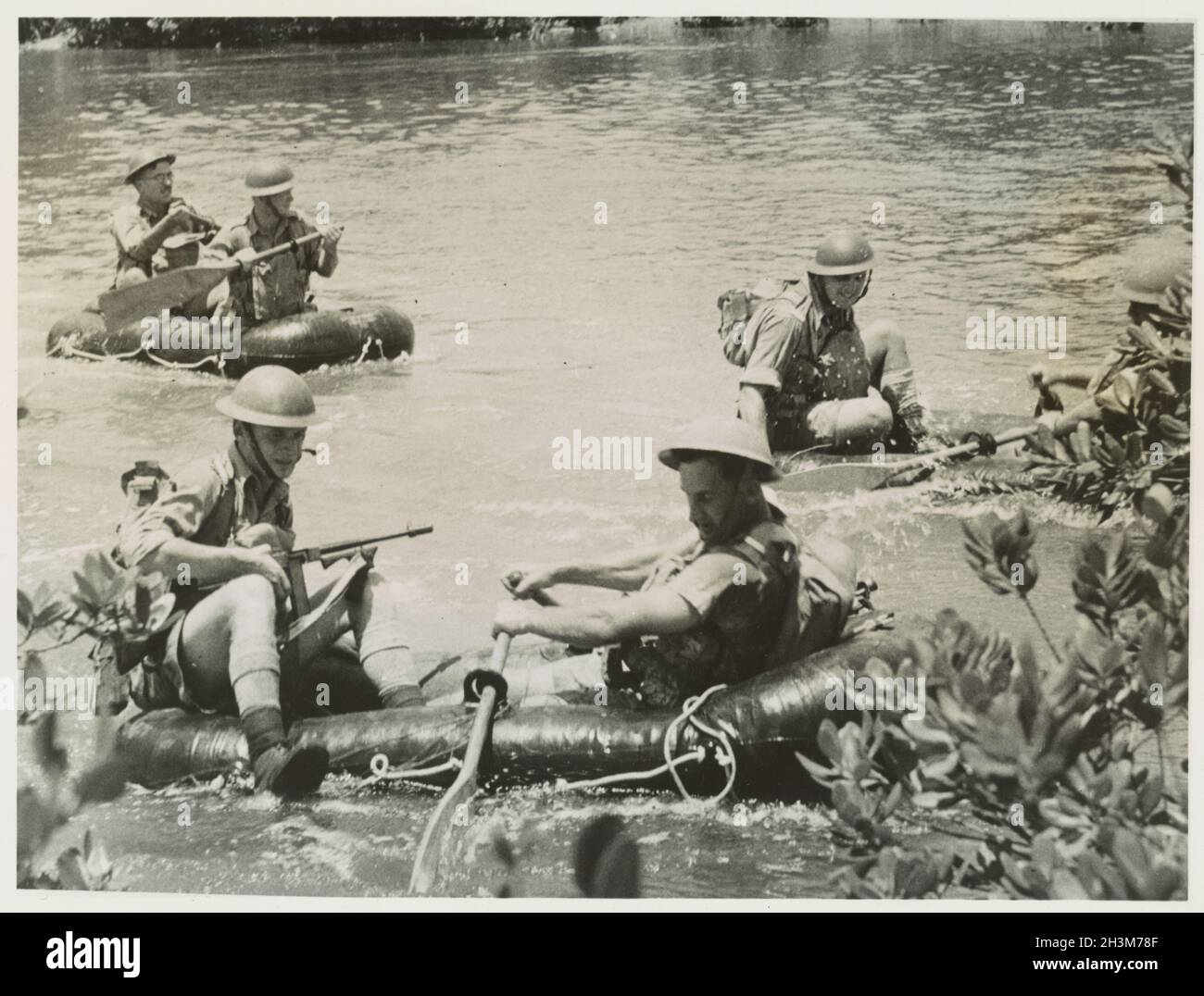 Une photo d'époque vers 1941 montrant des soldats de l'armée australienne traversant une rivière de la jungle dans des bateaux gonflables en caoutchouc pendant l'invasion japonaise de la Malaisie et la chute de Singapour Banque D'Images