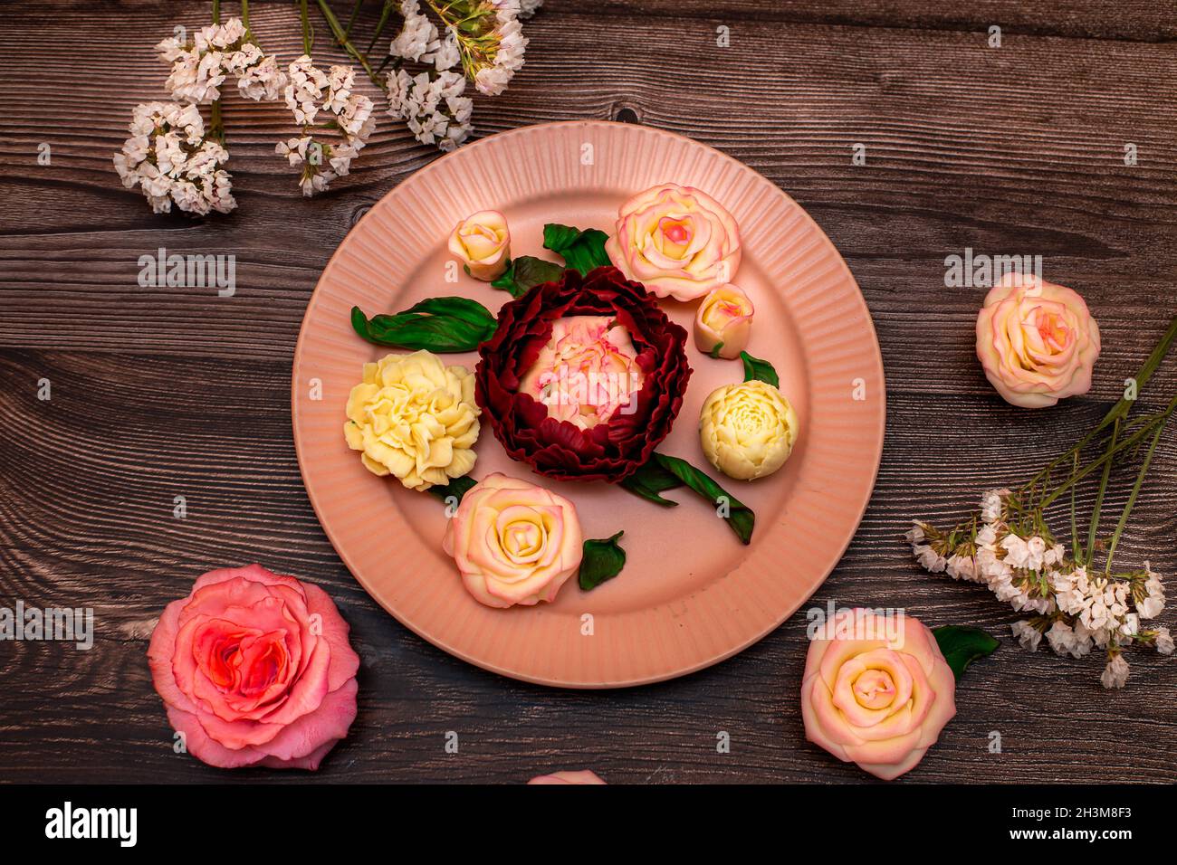 Roses rose chocolat, roses blanches, pivoines sur fond de bois sombre. Banque D'Images