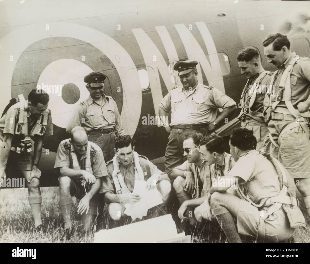 Photo vintage vers 1942 des pilotes de la RAF britannique et des chasseurs néerlandais discutant des plans de patrouille à côté d'un avion de la RAF pendant l'invasion japonaise de Malaya et la chute de Singapour Banque D'Images