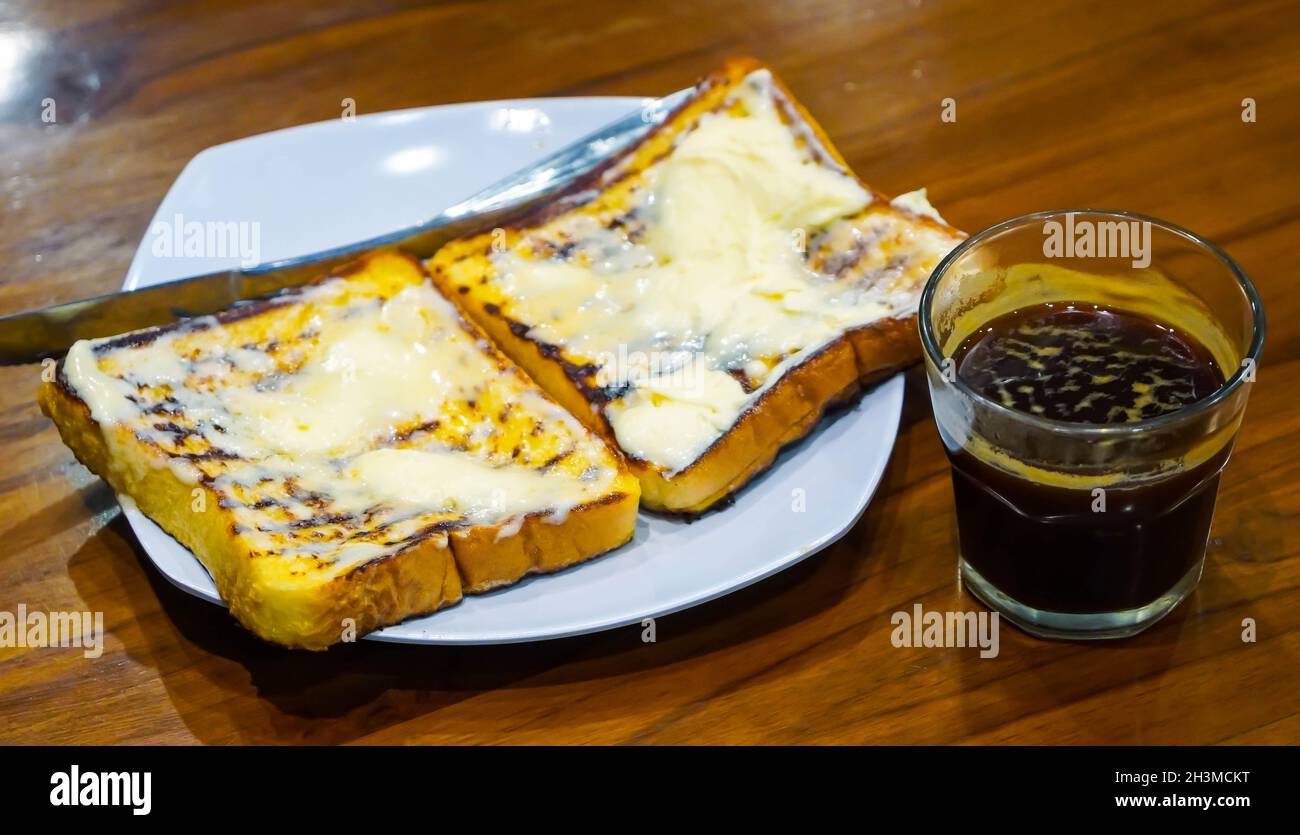 Délicieux sandwich grillé avec gril au beurre fondu et une tasse de café au foyer sélectif. Banque D'Images