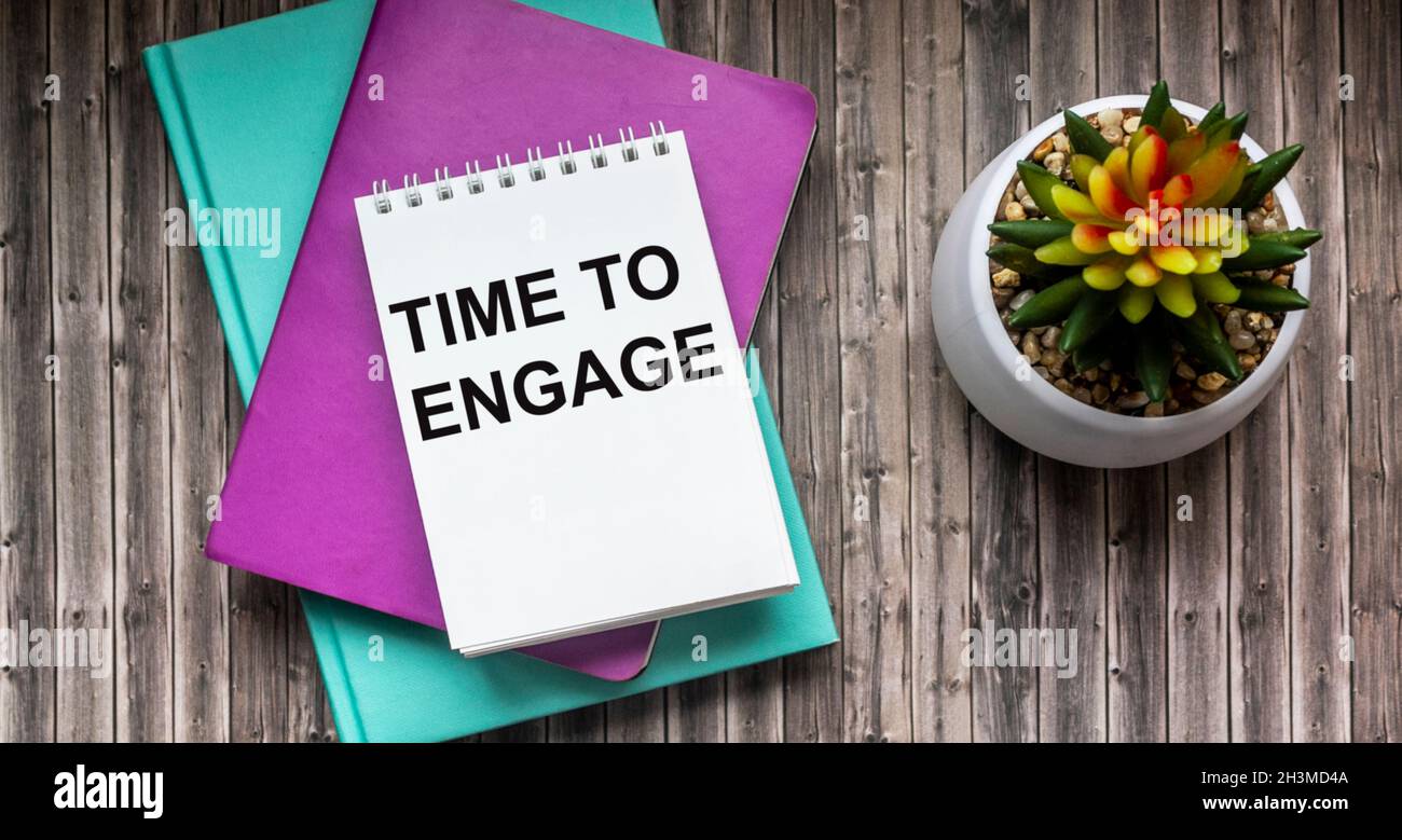 Temps d'engagement , texte sur le bloc-notes blanc.Des blocs-notes de couleur et un cactus se trouvent sur une table en bois. Banque D'Images