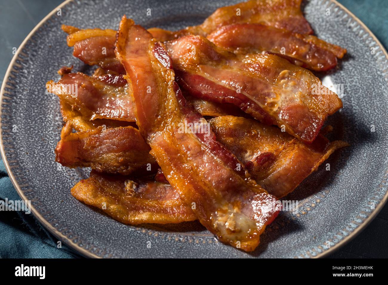 Bacon graisseux pour le petit déjeuner sur une assiette Banque D'Images