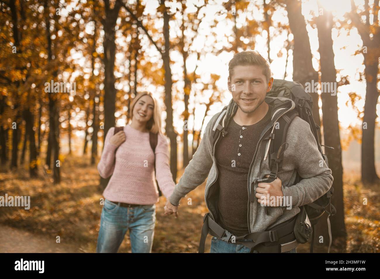 Un couple charmant de voyageurs marchant le long D'UN sentier forestier Banque D'Images