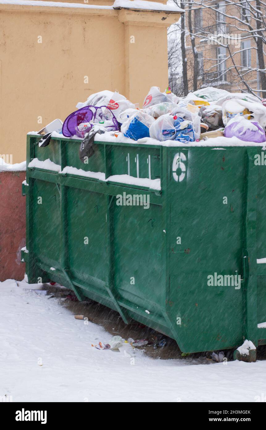 Saint-Pétersbourg, Russie - 26 janvier 2019 : benne à ordures verte n° 6 remplie de sacs en plastique et recouverte de neige pendant une chute de neige Banque D'Images