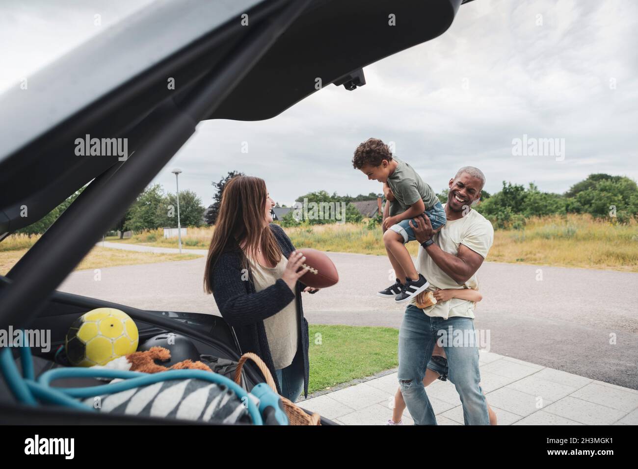 Homme joyeux jouant avec les enfants par femme Banque D'Images