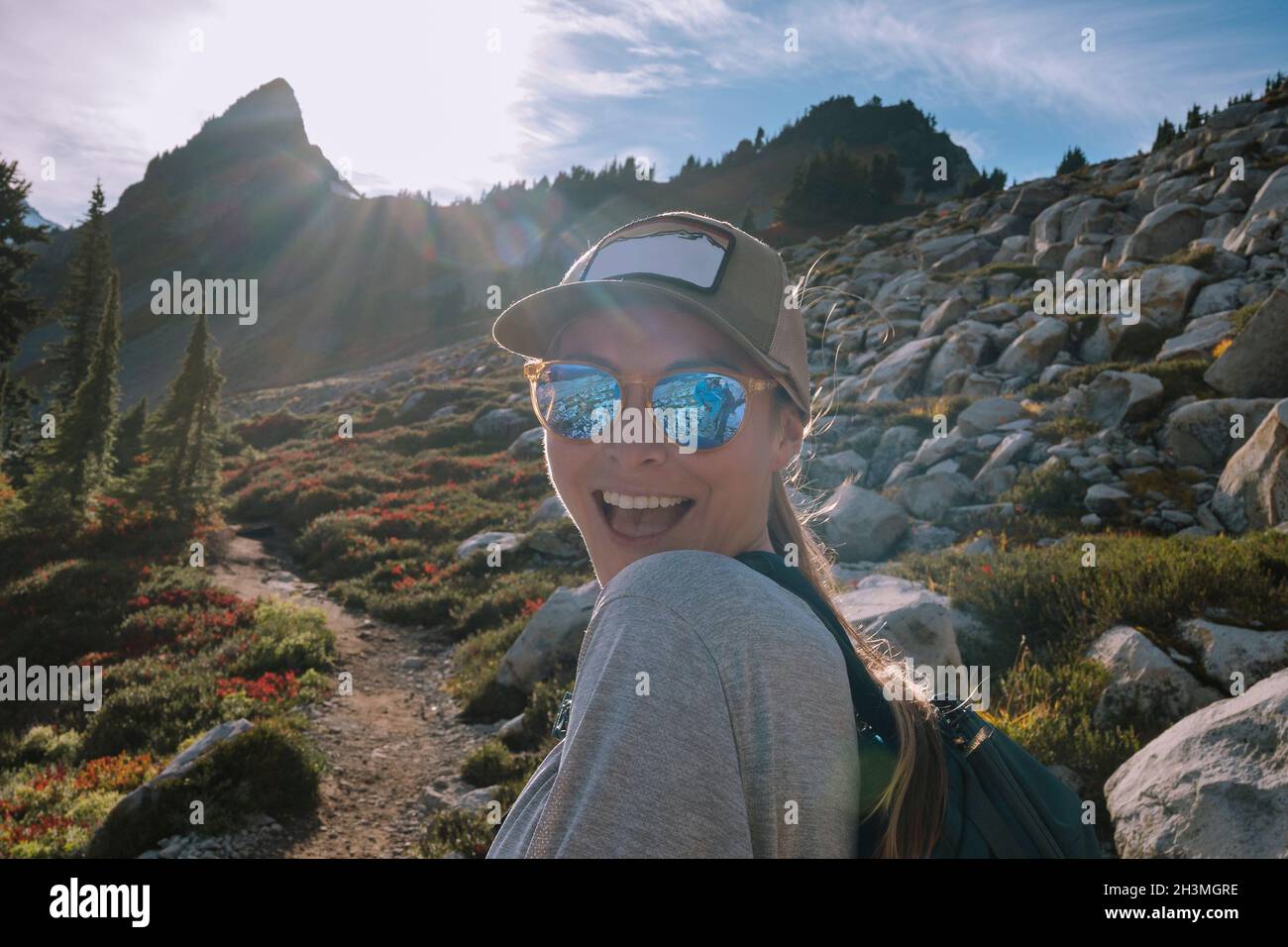 Gros plan de Happy Female Hiker avec lunettes de soleil sur la vue de l'appareil photo Banque D'Images