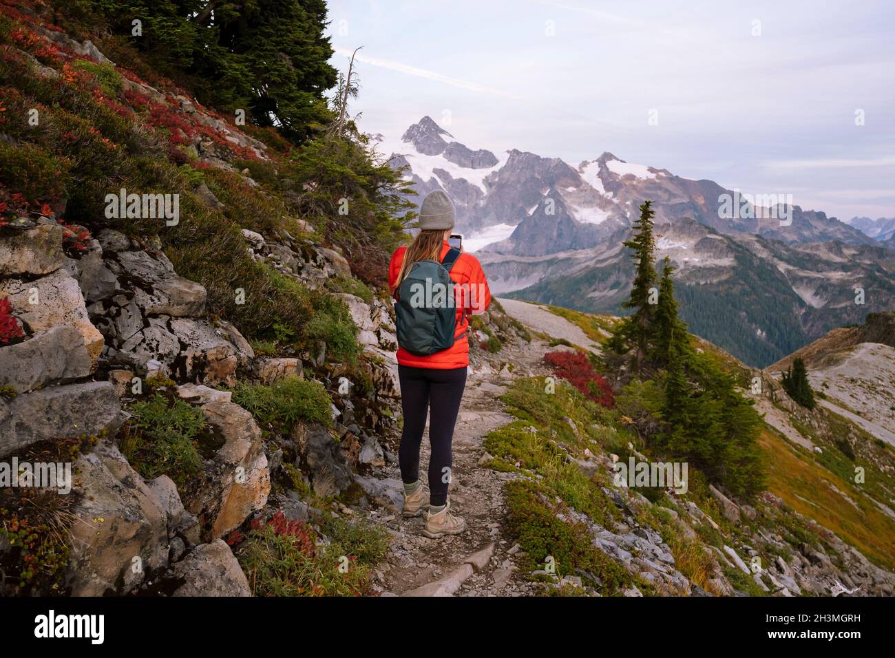 Femme de randonnée prenant des photos sur un sentier dans les Cascades du Nord Banque D'Images