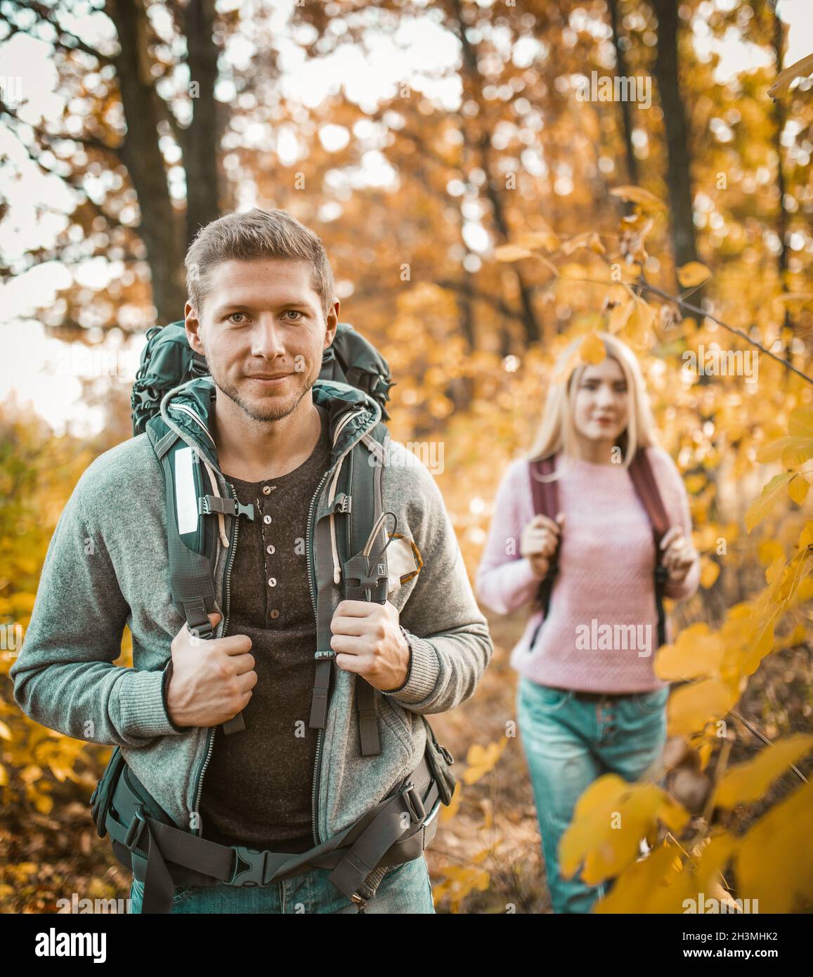 Deux Backpackers marchant à travers la forêt d'automne Banque D'Images