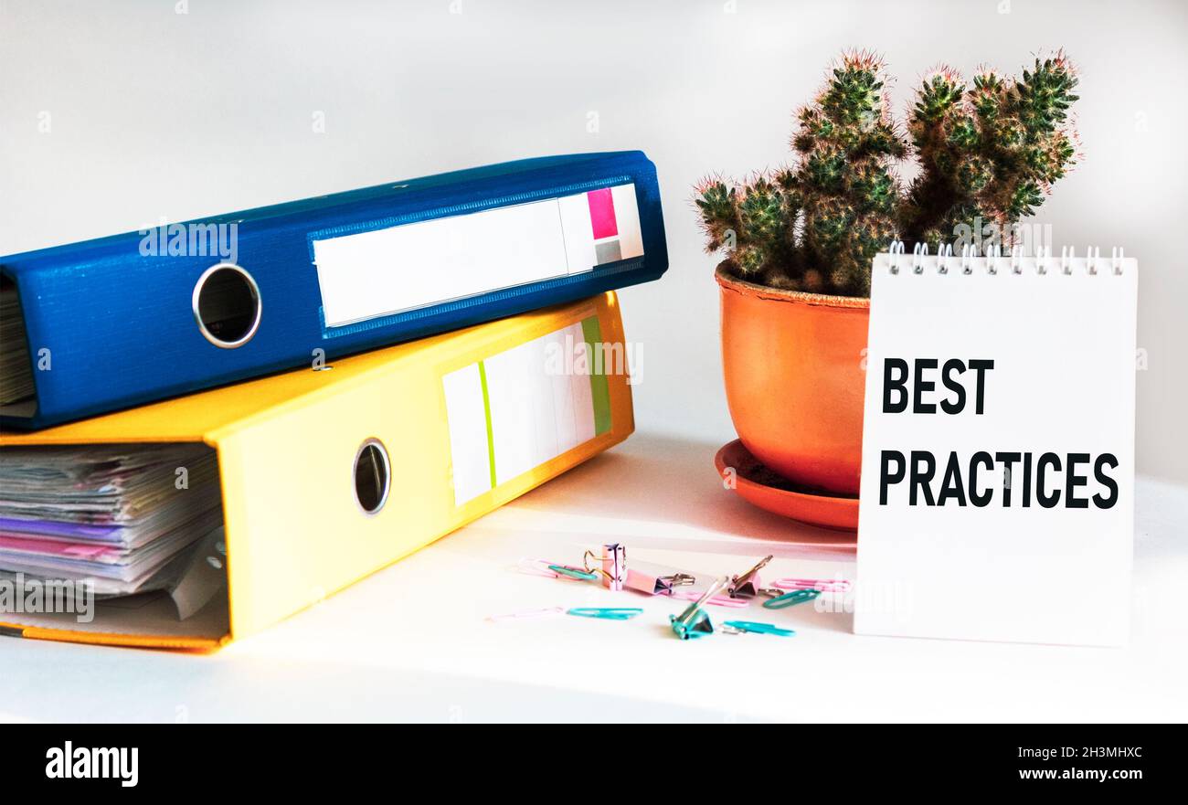 Terme métier, expression métier.Texte sur bloc-notes - meilleure pratique.Dossiers, trombones et cactus sur fond blanc Banque D'Images