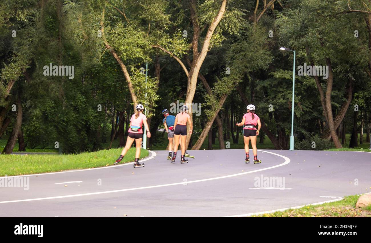 Les patineurs roulent le long de la route asphaltée.Ski de fond avec motomarines et arrière-plan de la forêt....Le concept du sport, un mode de vie sain. Banque D'Images