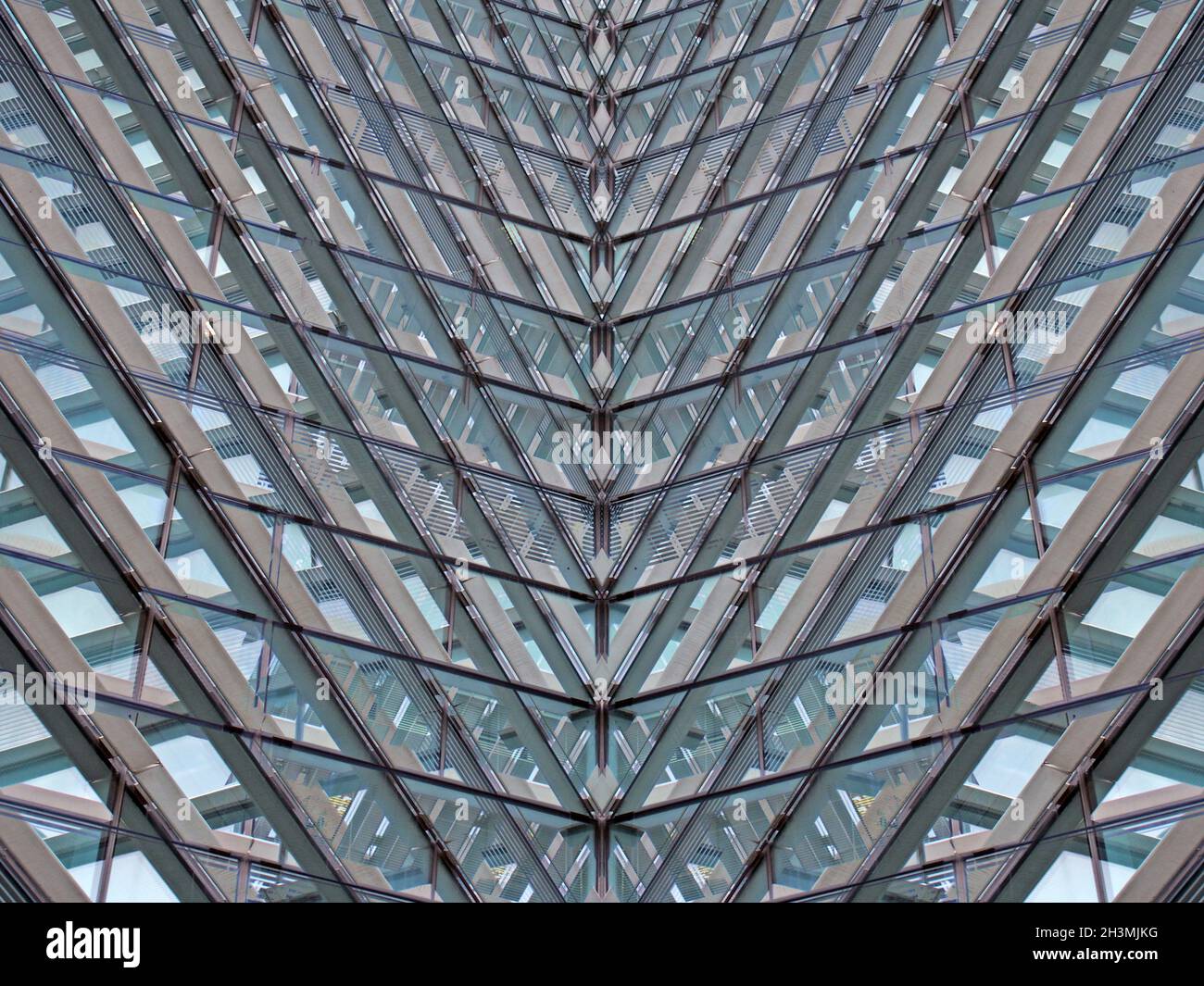 Un résumé architectural moderne plein cadre avec des formes géométriques futuristes et des lignes réfléchis angulaires en verre bleu et en acier Banque D'Images
