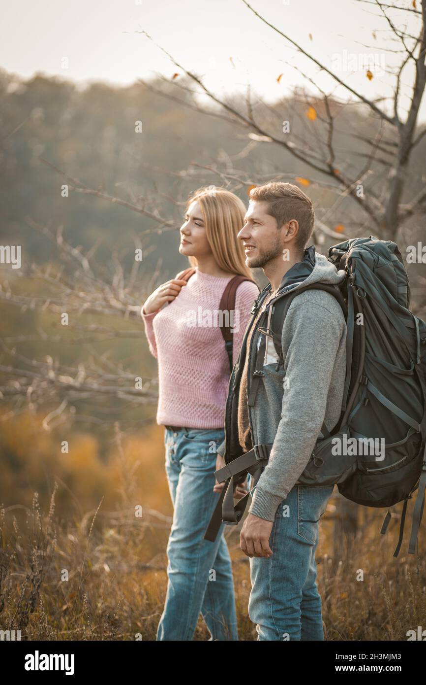 Couple de touristes admirant le paysage naturel se tenant sur un côté de montagne.Vue latérale d'un homme et d'une femme avec des sacs à dos sont hik Banque D'Images