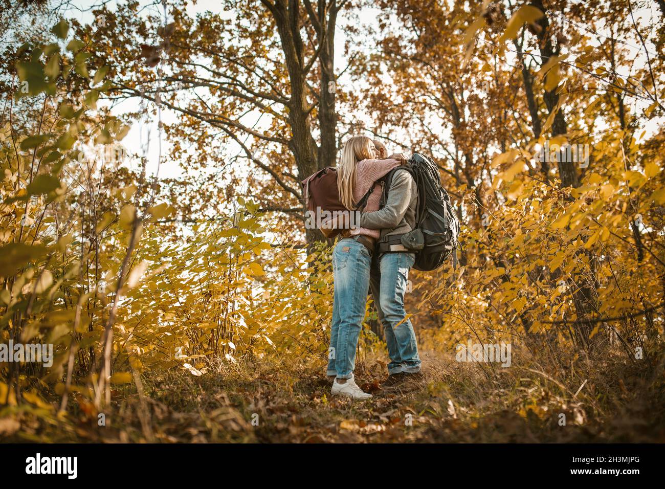 Un couple de voyageurs épris s'embrasse en admirant la nature de l'automne.Les jeunes s'embrassent dans une nature automnale multicolore.Tir fro Banque D'Images