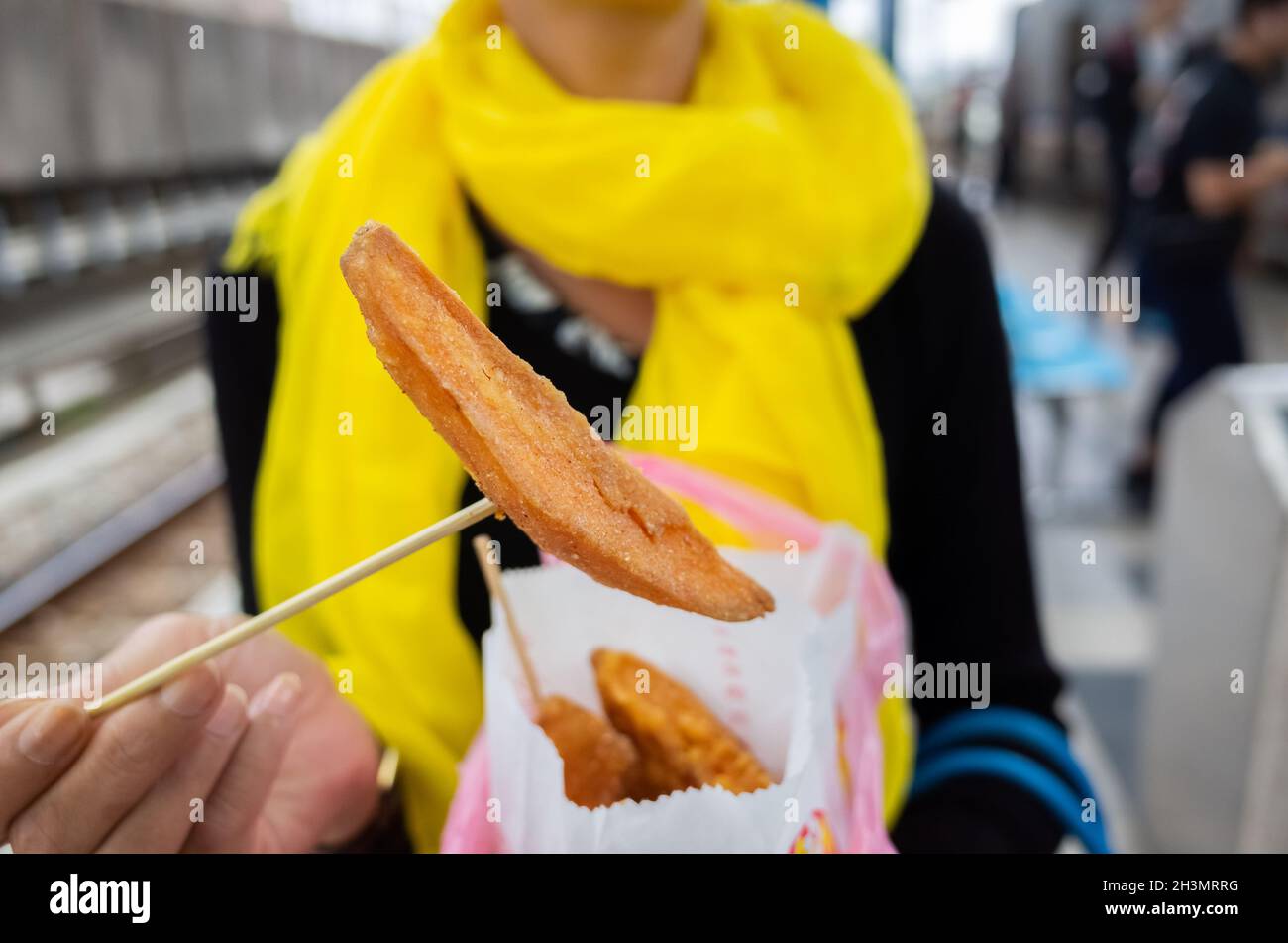 Une femme mange des frites de patate douce taïwanaises Banque D'Images